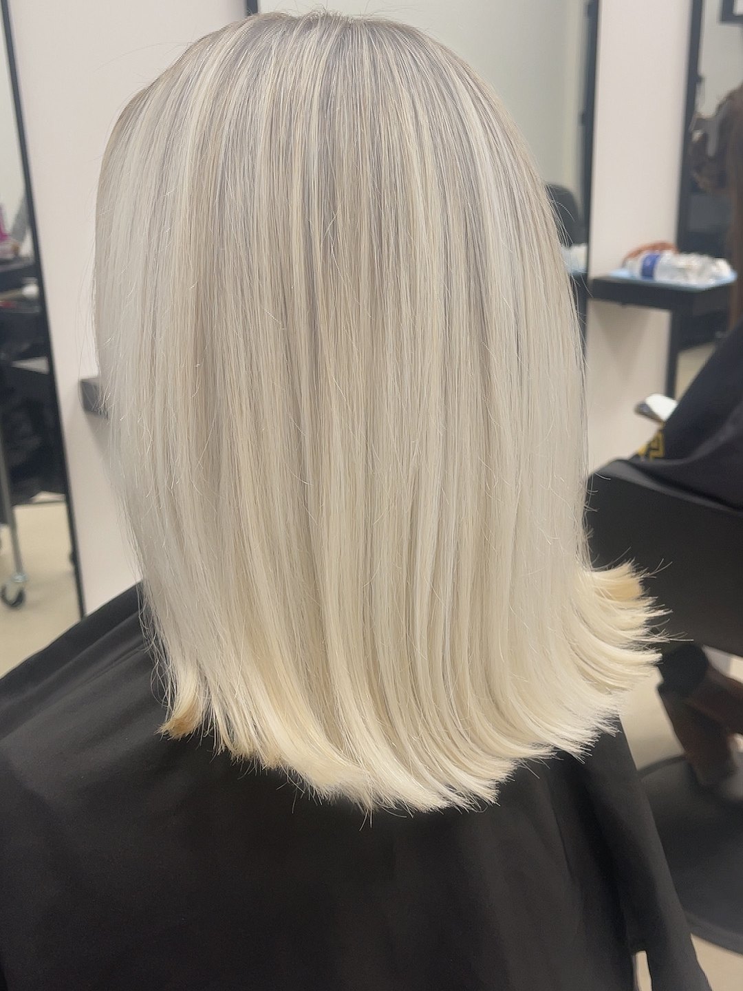 Een platinablonde bob, gezien van achteren in de salon