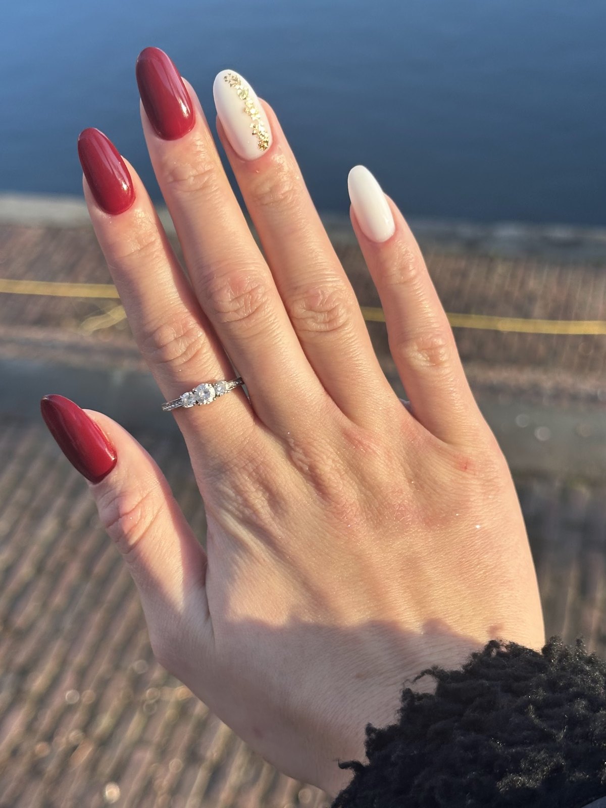 Dieprode en witte amandelnagels met een gouden detail